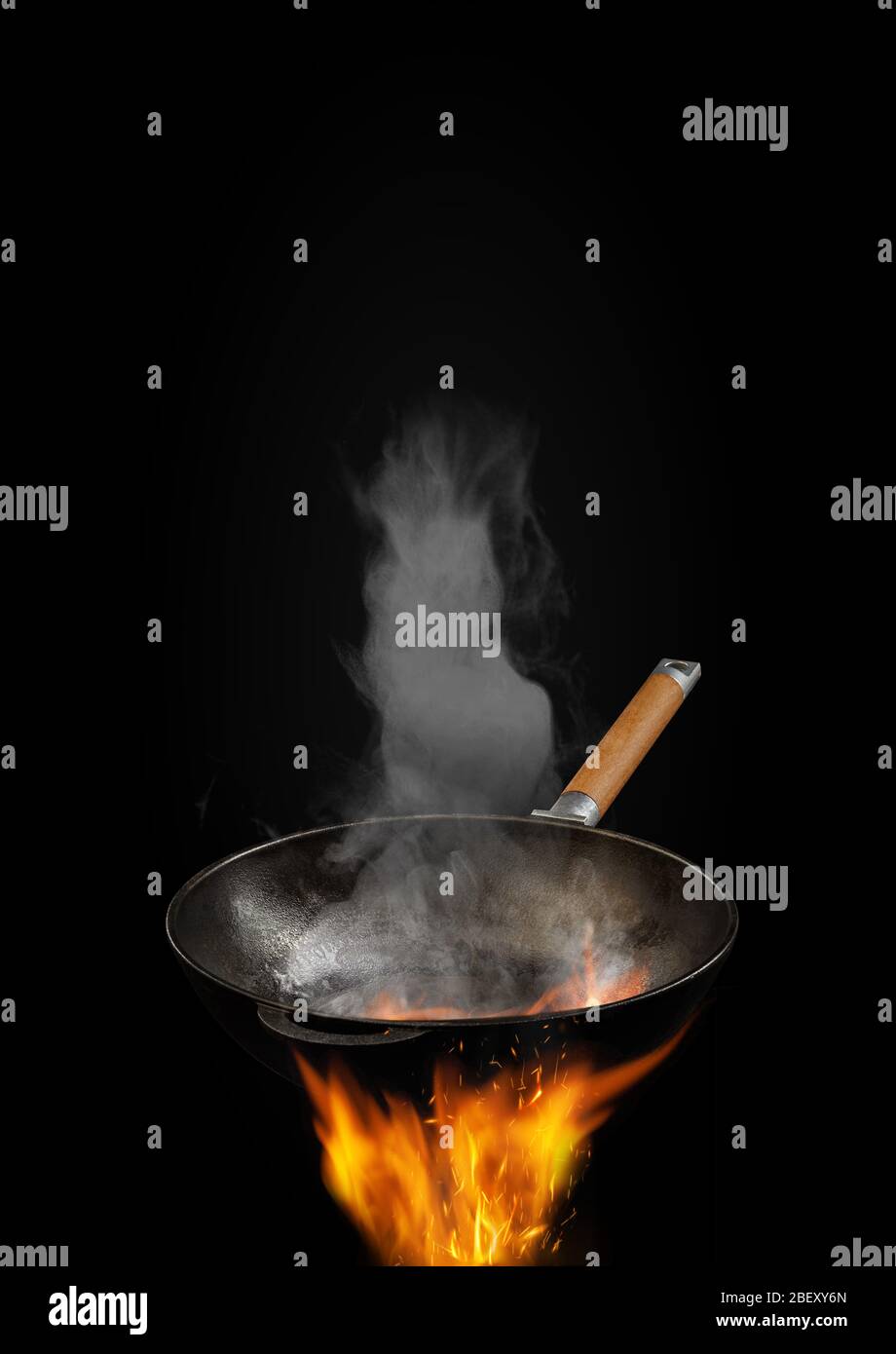 Vuoto burning wok padella con fumo sopra fuoco contro sfondo nero. Concetto  di cucina. Mockup, template per collage, testo o immagini. Primo piano Foto  stock - Alamy