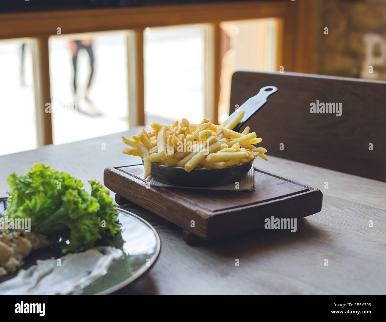 Patatine fritte in padella su tavolo di legno Foto Stock