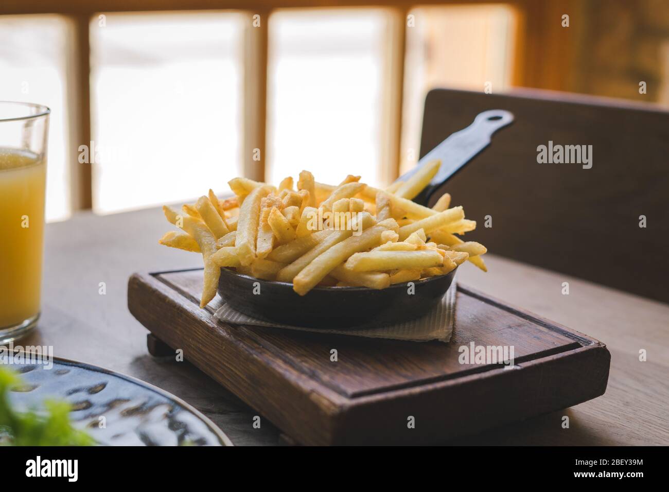 Patatine fritte in padella su tavolo di legno Foto Stock
