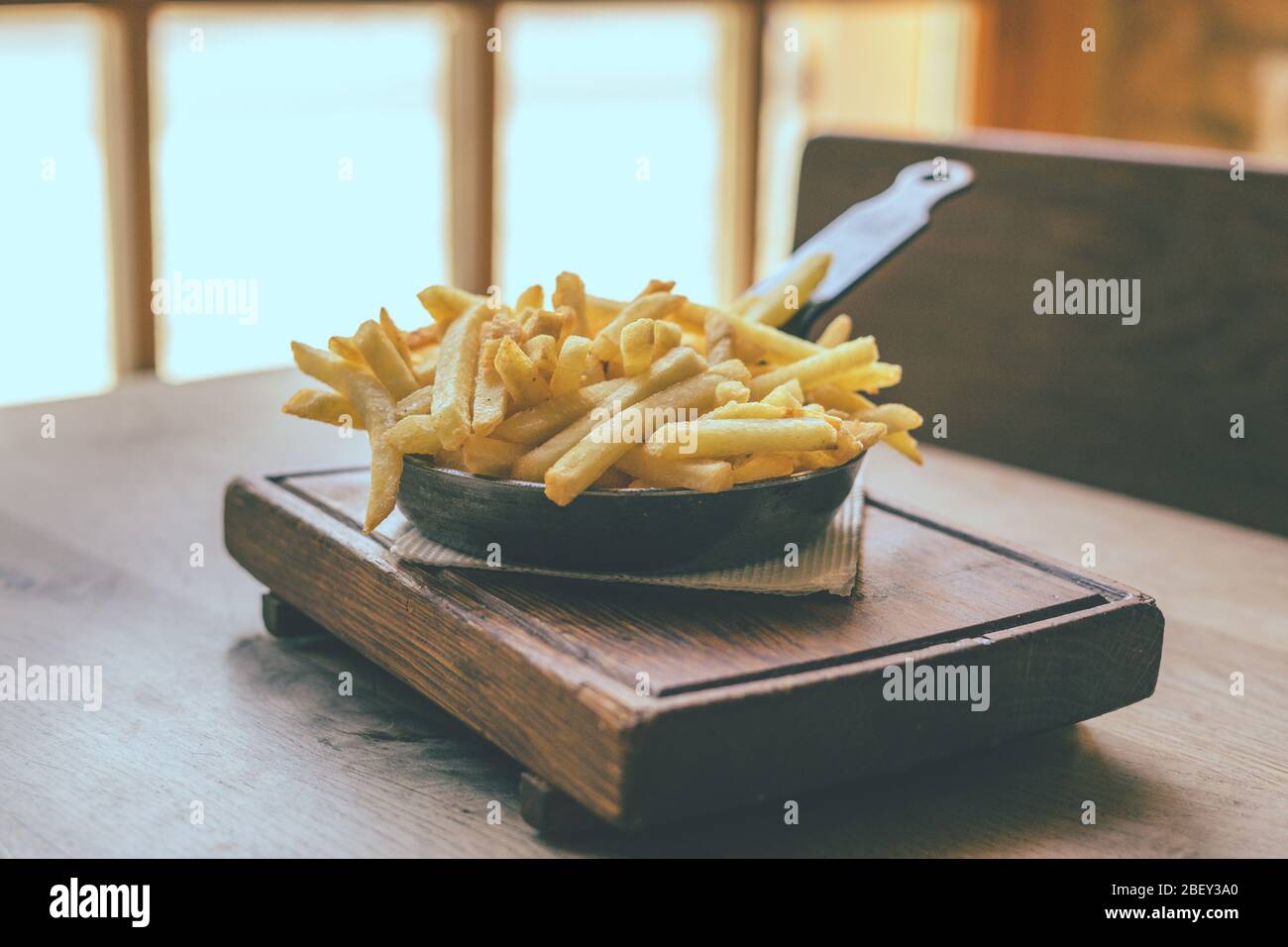 Patatine fritte in padella su tavolo di legno Foto Stock