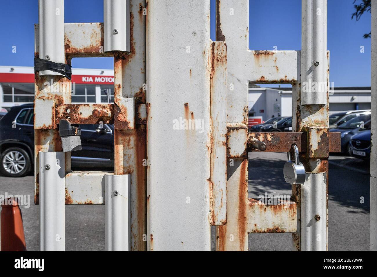 NOTA: IMMAGINE 2 DI UN SET DI 35 IMMAGINI CON PORTE CHIUSE DI AZIENDE E LUOGHI CHIUSI DURANTE il blocco del Regno Unito due lucchetti di sicurezza bulloni su un pedone e l'ingresso del veicolo a un concessionario di auto Kia a Bristol per impedire l'accesso, come il Regno Unito continua a bloccare per contribuire a frenare la diffusione del coronavirus. Foto Stock