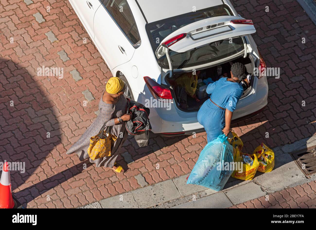 Città del Capo, Sudafrica. 2019. Donne che caricano i sacchetti di shopping nel tronco di un'automobile bianca a Città del Capo. Foto Stock