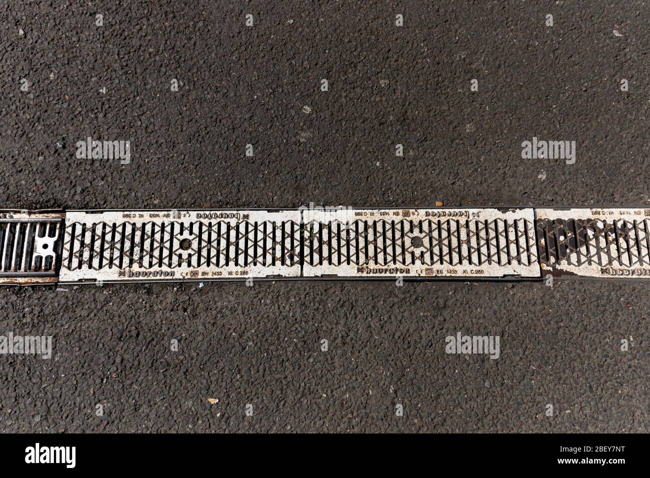 una vista ravvicinata di una piccola canaletta di drenaggio su un parcheggio asfaltato Foto Stock