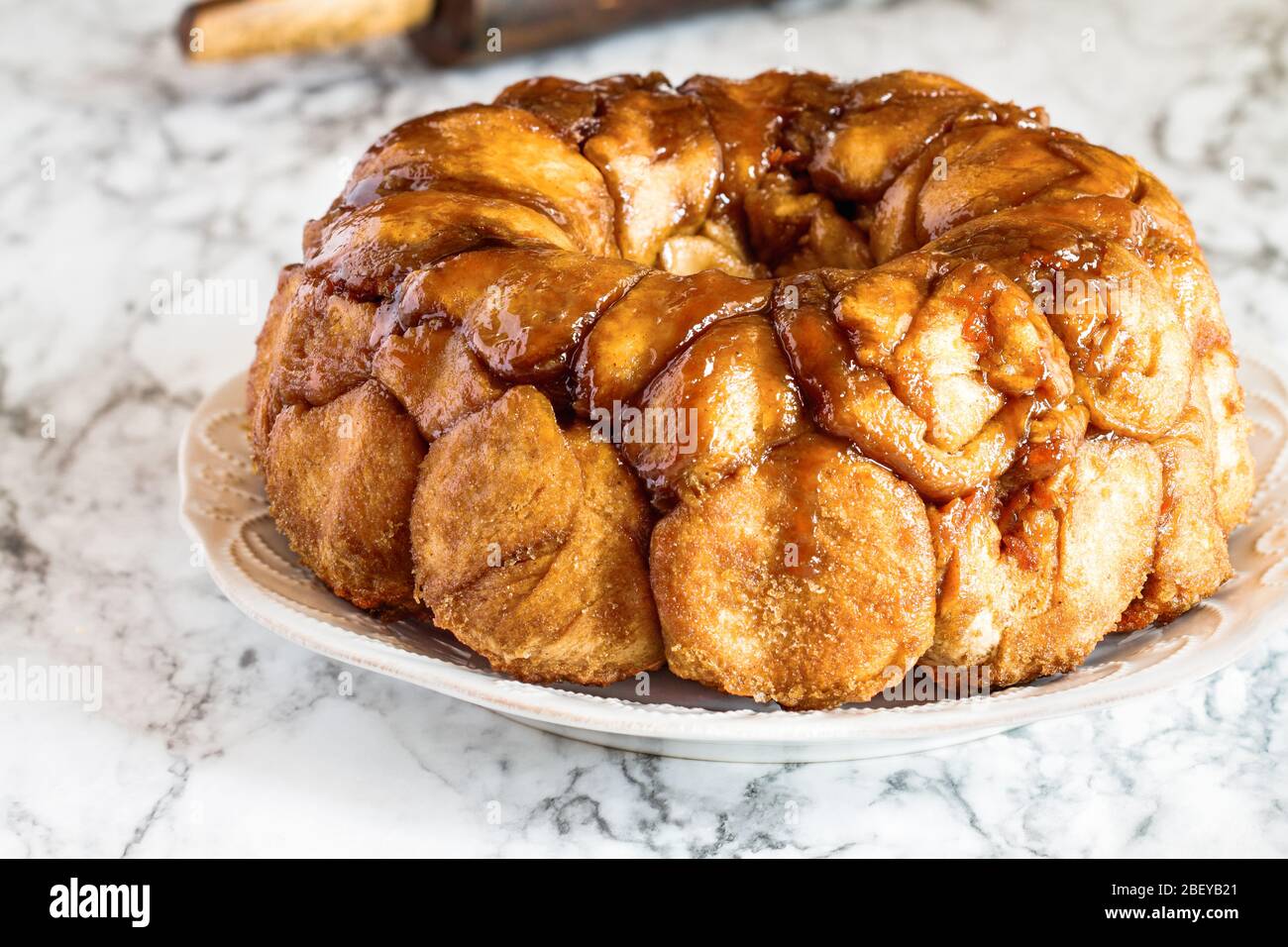 Dessert pasquale di Pull Apart torta torta torta di scimmie pane. Torta di lievito fatta con cannella, carote, noci e glassa di zucchero marrone. Messa a fuoco selettiva w Foto Stock