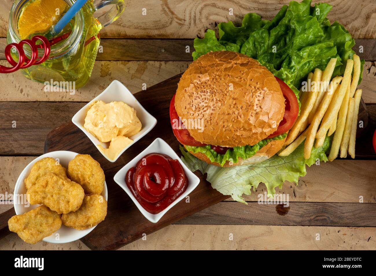 Hamburger, pepite di pollo e patate fritte con salse, vista dall'alto Foto Stock