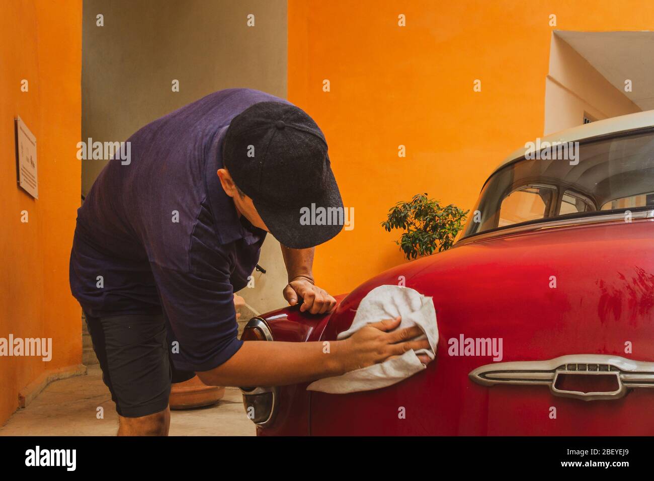 Persona lucidare la sua Chevrolet Vintage Belair classica auto, Havana città vecchia, Cuba Foto Stock