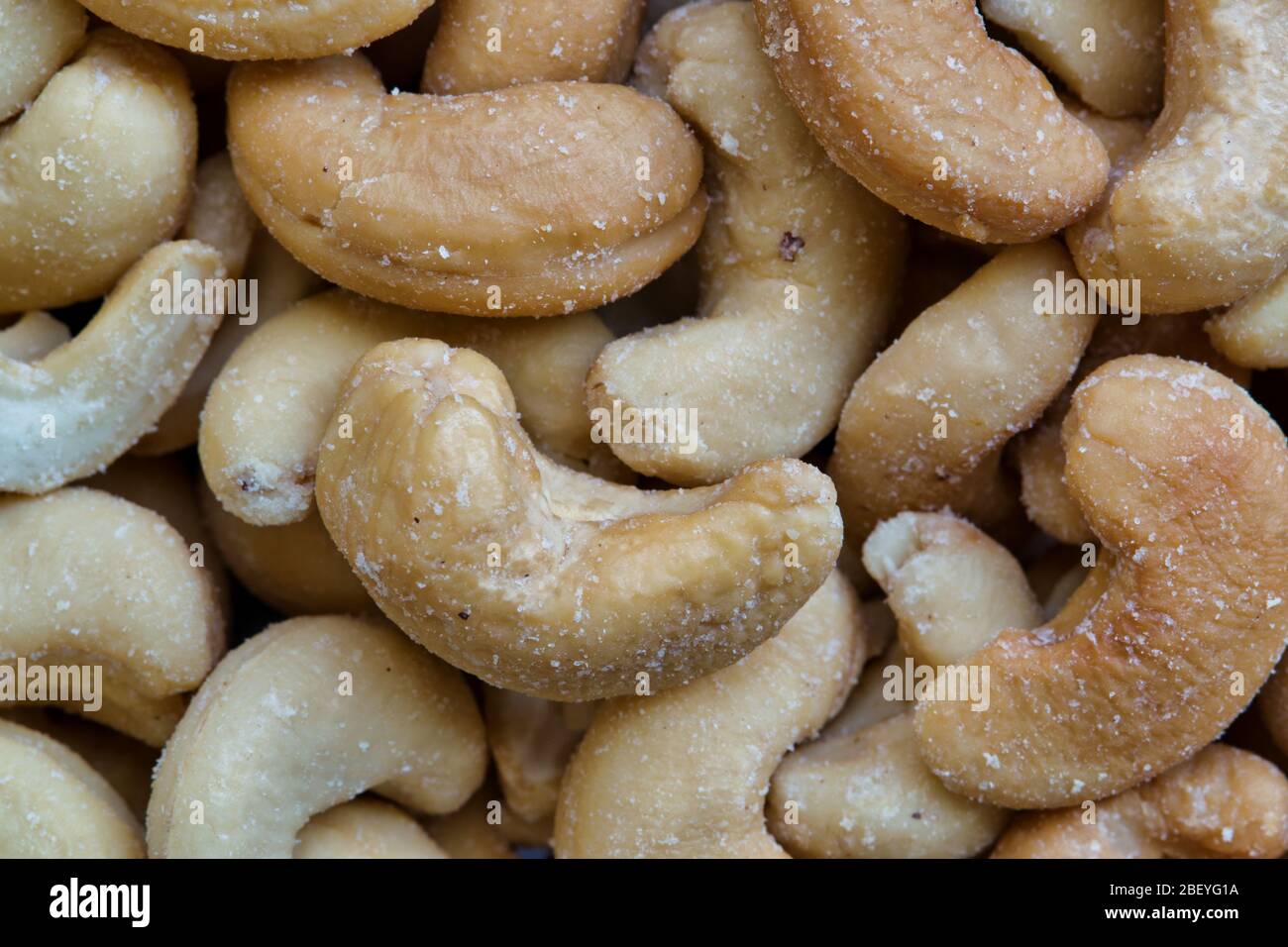 Noci di cashew, arrostite e leggermente salate. Immagine macro, fotogramma intero. Nativi del Brasile sono comuni come uno spuntino e utilizzati come ingredienti di cottura. Foto Stock