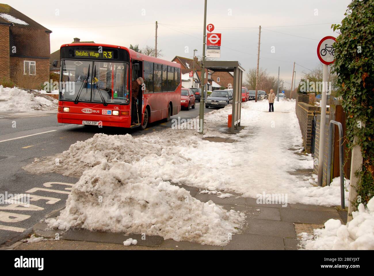 Uomo anziano che discende da un autobus a un solo ponte in condizioni di neve Foto Stock