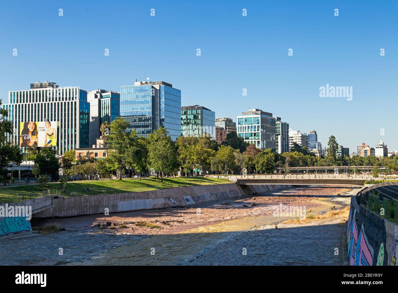 SANTIAGO, REGIONE METROPOLITANA, CILE. Skyline della città, vista dal parco costiero. Fiume Mapocho in primo piano. Foto Stock