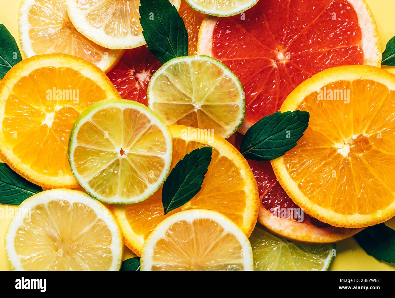 Motivo Flatlay di agrumi arancio, limone, lime e pompelmo fette di fondo. Vista dall'alto. Design minimo. Foto Stock