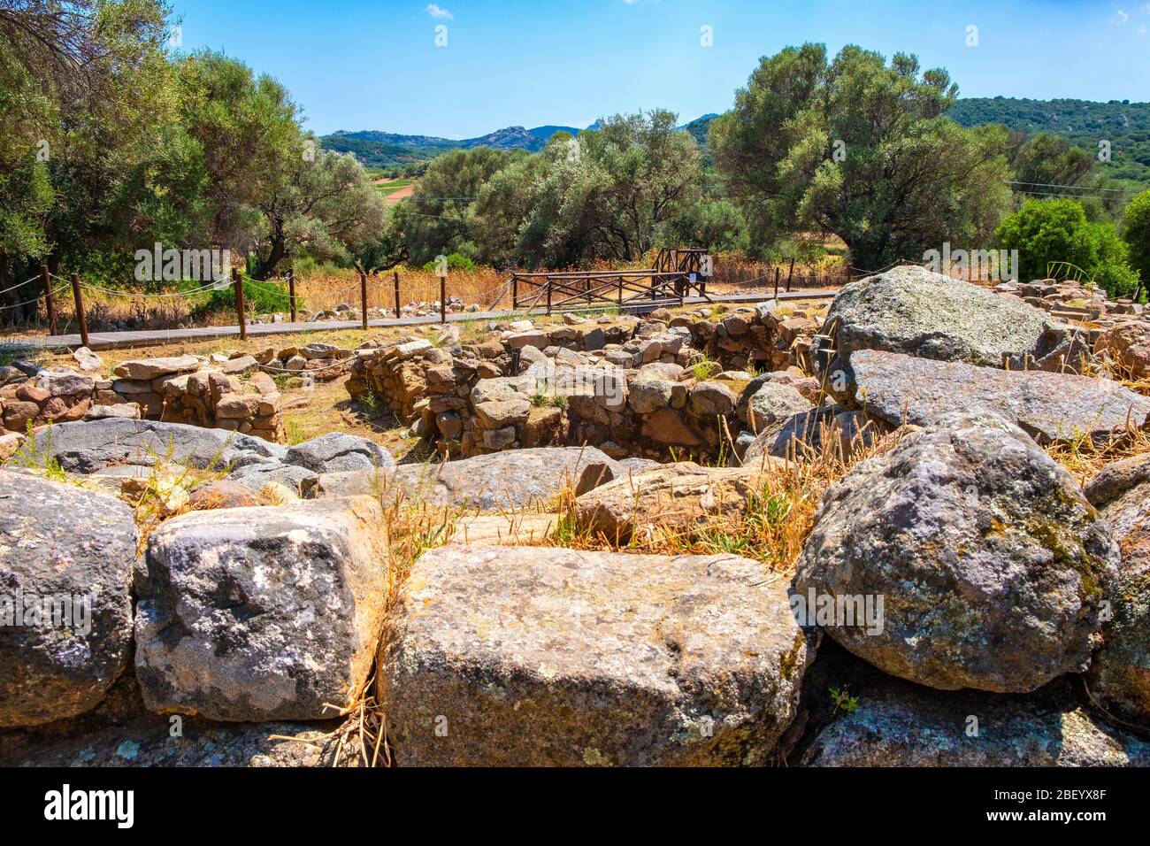 Arzachena, Sardegna / Italia - 2019/07/19: Rovine archeologiche del complesso nuragico la Prisgiona - Nuraghe la Prisgiona - con resti di pietra arrotondata Foto Stock