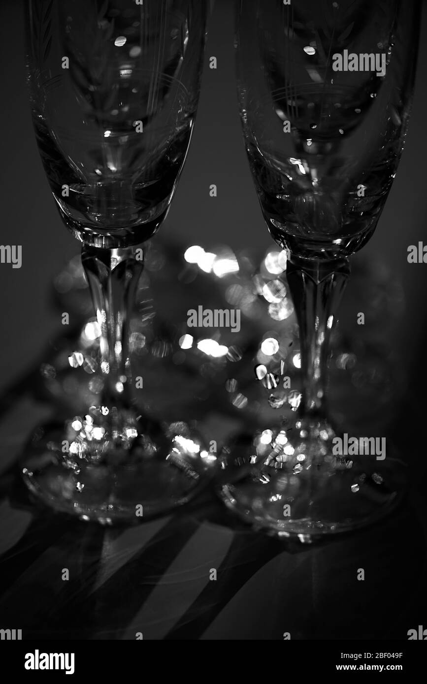 Bicchieri di champagne in cristallo illuminato in una stanza buia. Concetto : minimalismo artistico. Foto Stock