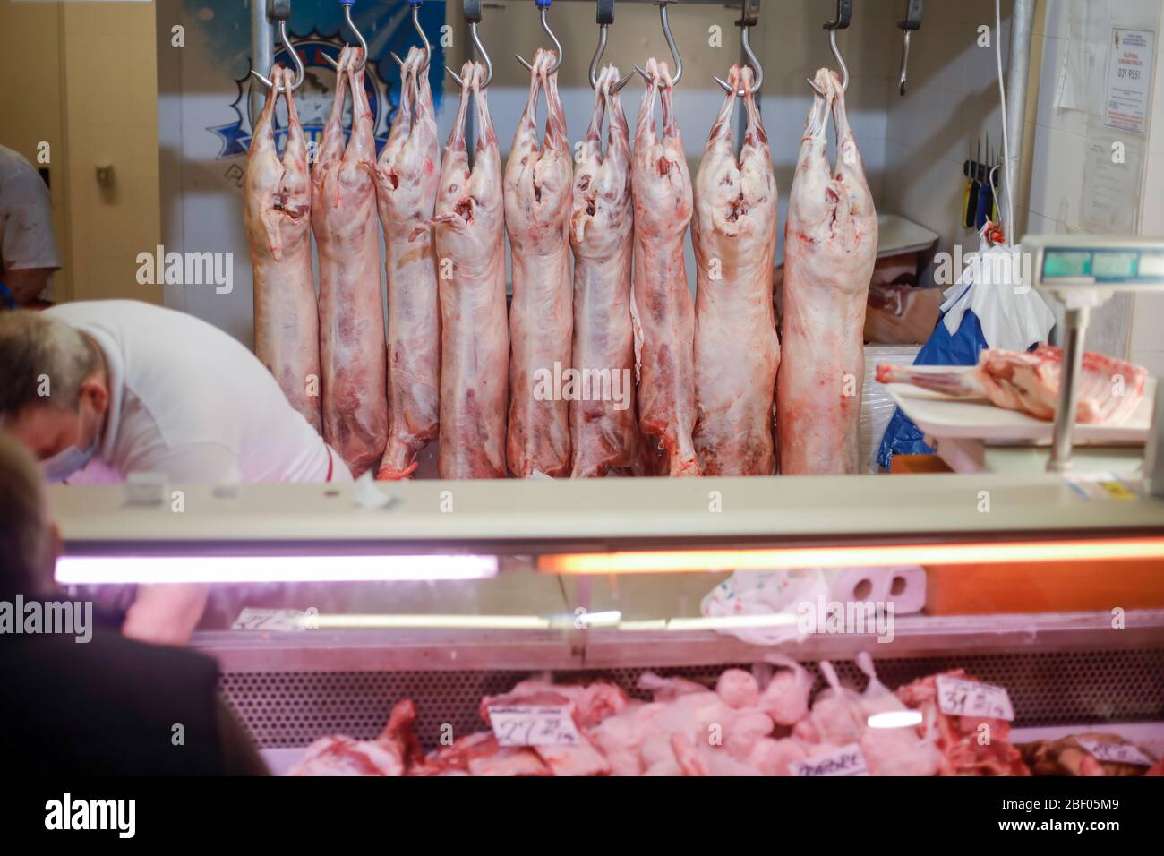 Bucarest, Romania - 16 aprile 2020: Carcassa di agnello appesa da ganci di ferro per la vendita in un macellaio rumeno prima di Pasqua. Foto Stock