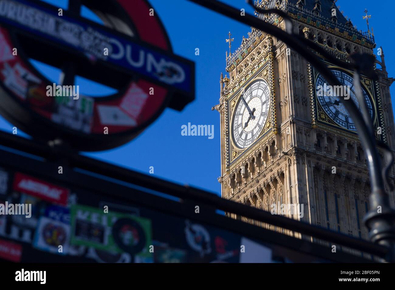 Big ben, visto attraverso l'indicazione per la stazione della metropolitana di Westminster. Il Palazzo di Westminster è il luogo d'incontro della Camera dei Comuni e del Hou Foto Stock