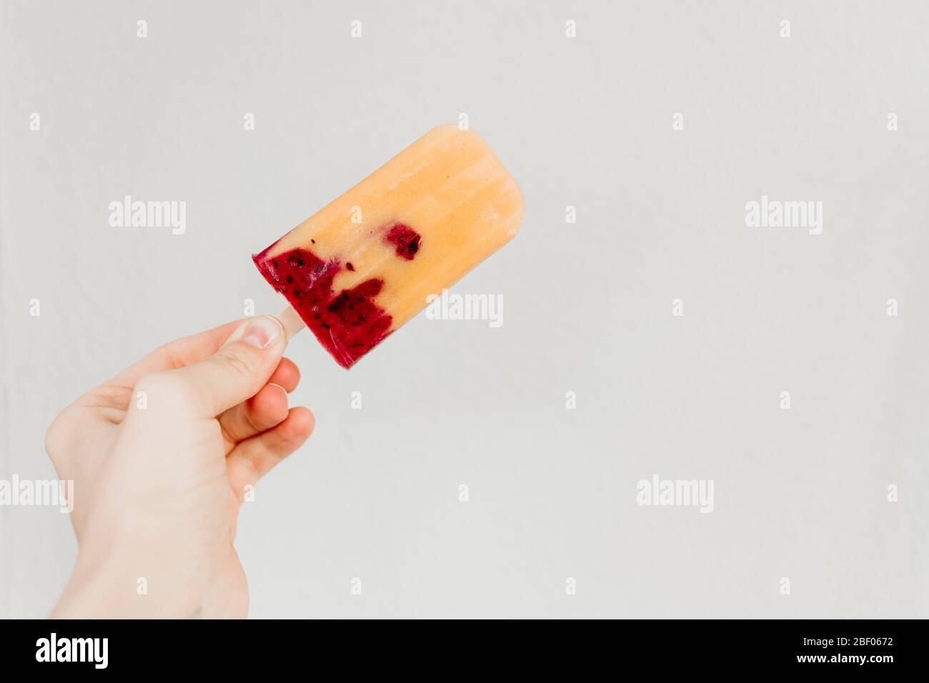 La frutta fatta in casa è composta da mango fresco, ribes nero e latte di cocco. Stile fotografico minimal. Foto Stock