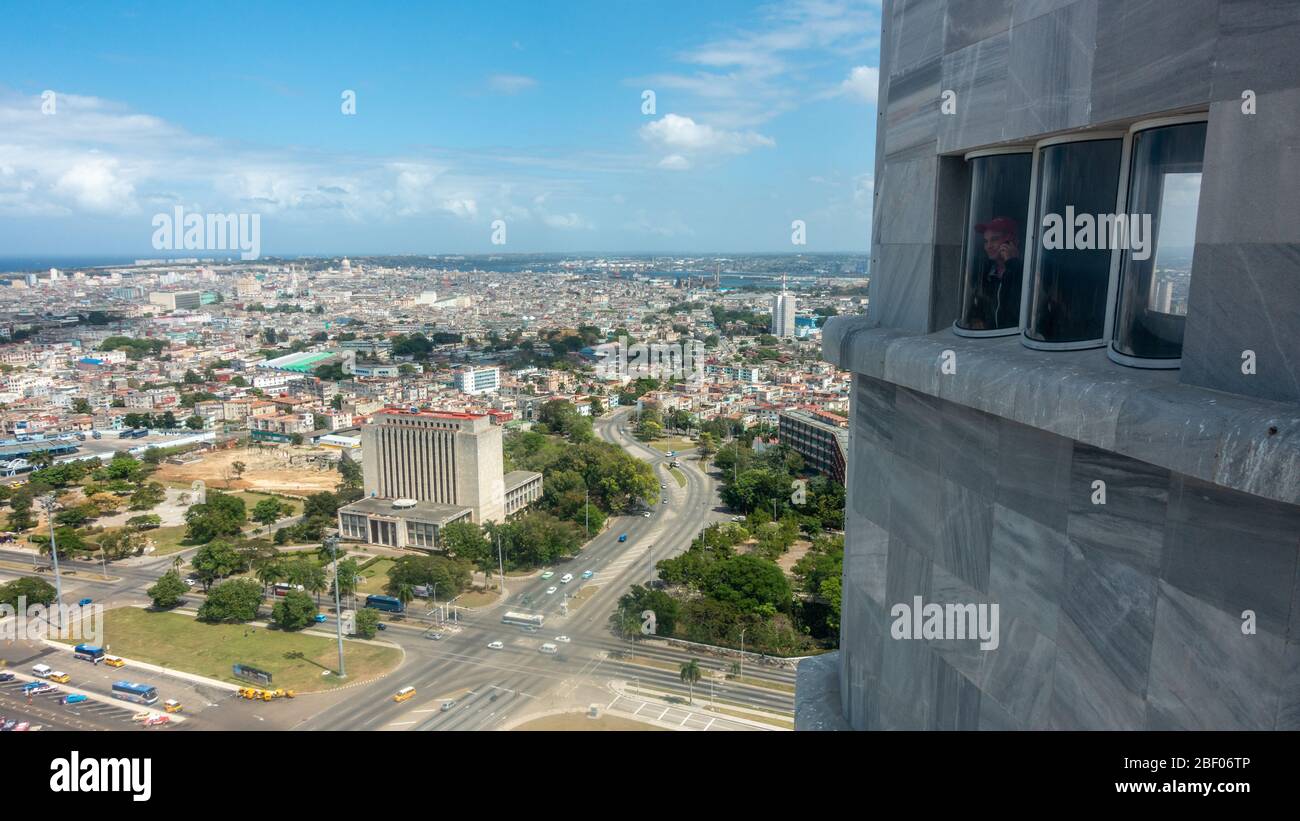 Vista aerea dalla cima della torre commemorativa di José Martí che si affaccia sulla città vecchia di l'Avana, con la persona che guarda dalla finestra, Plaza de la Revolución Foto Stock