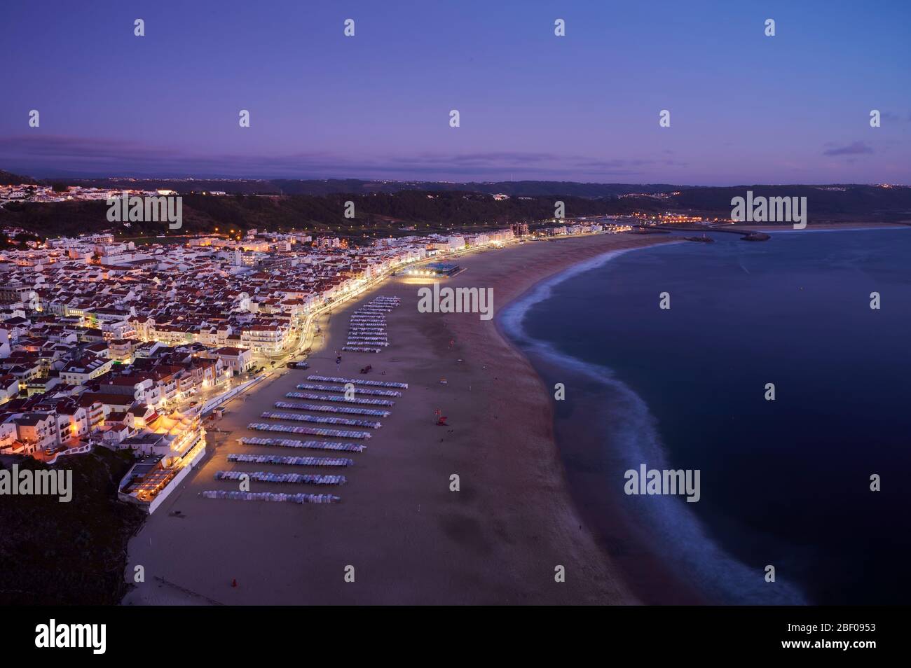 Vista alla fine della giornata sulla città e la spiaggia di Nazaré Foto Stock