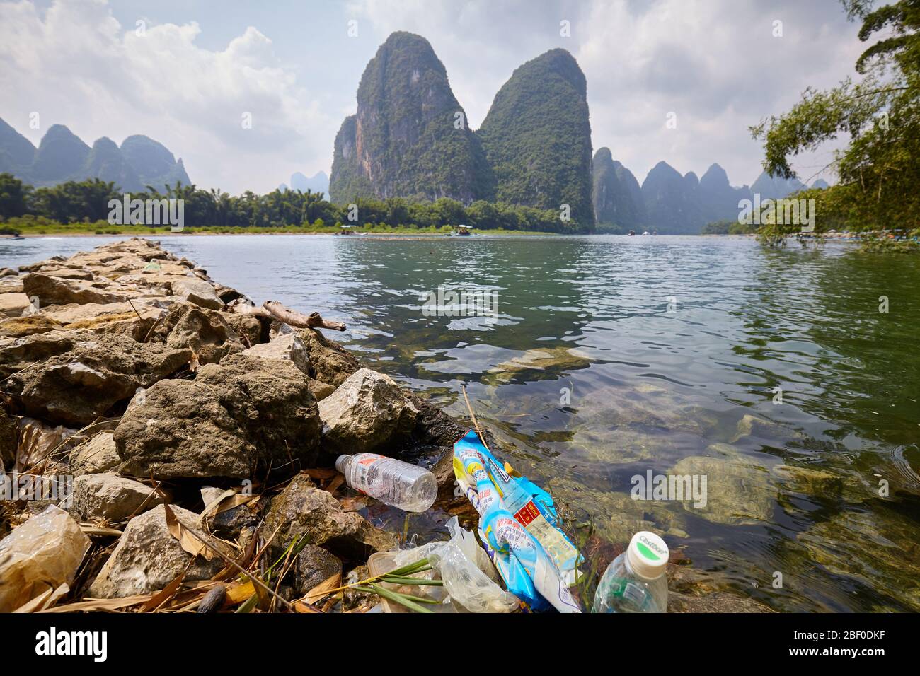 Xingping, Cina - 18 settembre 2017: Spazzatura di plastica sulla riva del fiume li, una delle principali attrazioni turistiche della Cina. Foto Stock