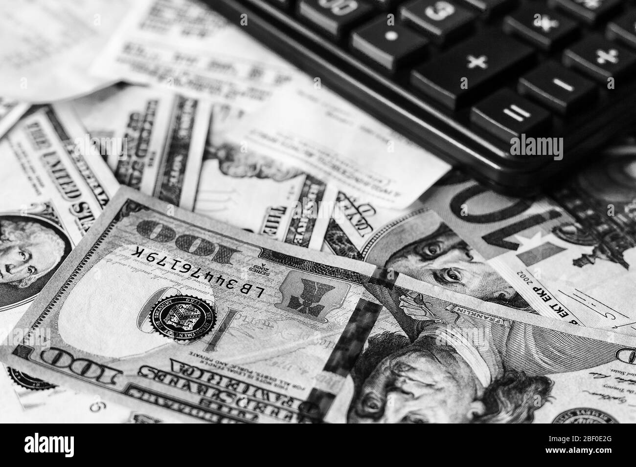 Sfondo con denaro dollari americani e euro fatture, assegno e calcolatore nero. Denaro contante. Immagine in bianco e nero. Foto Stock