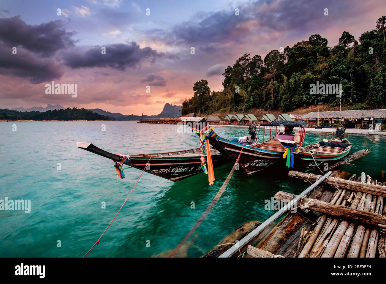 Bungalow galleggianti e barca a coda lunga all'alba nel Parco Nazionale di Khao Sok, Thailandia. Foto Stock