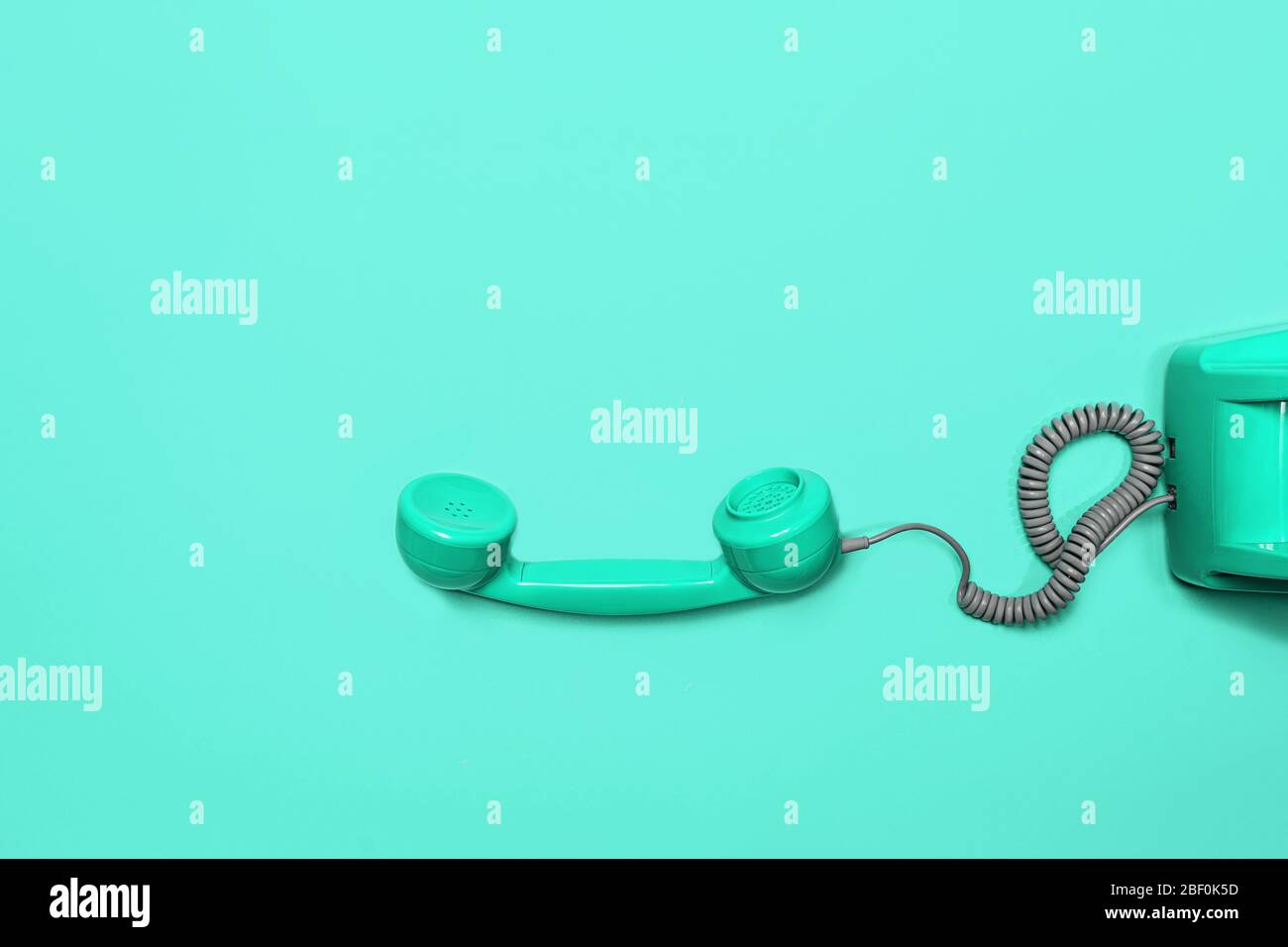 Telefono vecchio stile su sfondo verde menta neo. Stile moderno retro. Nuova vecchia tecnologia. Foto Stock