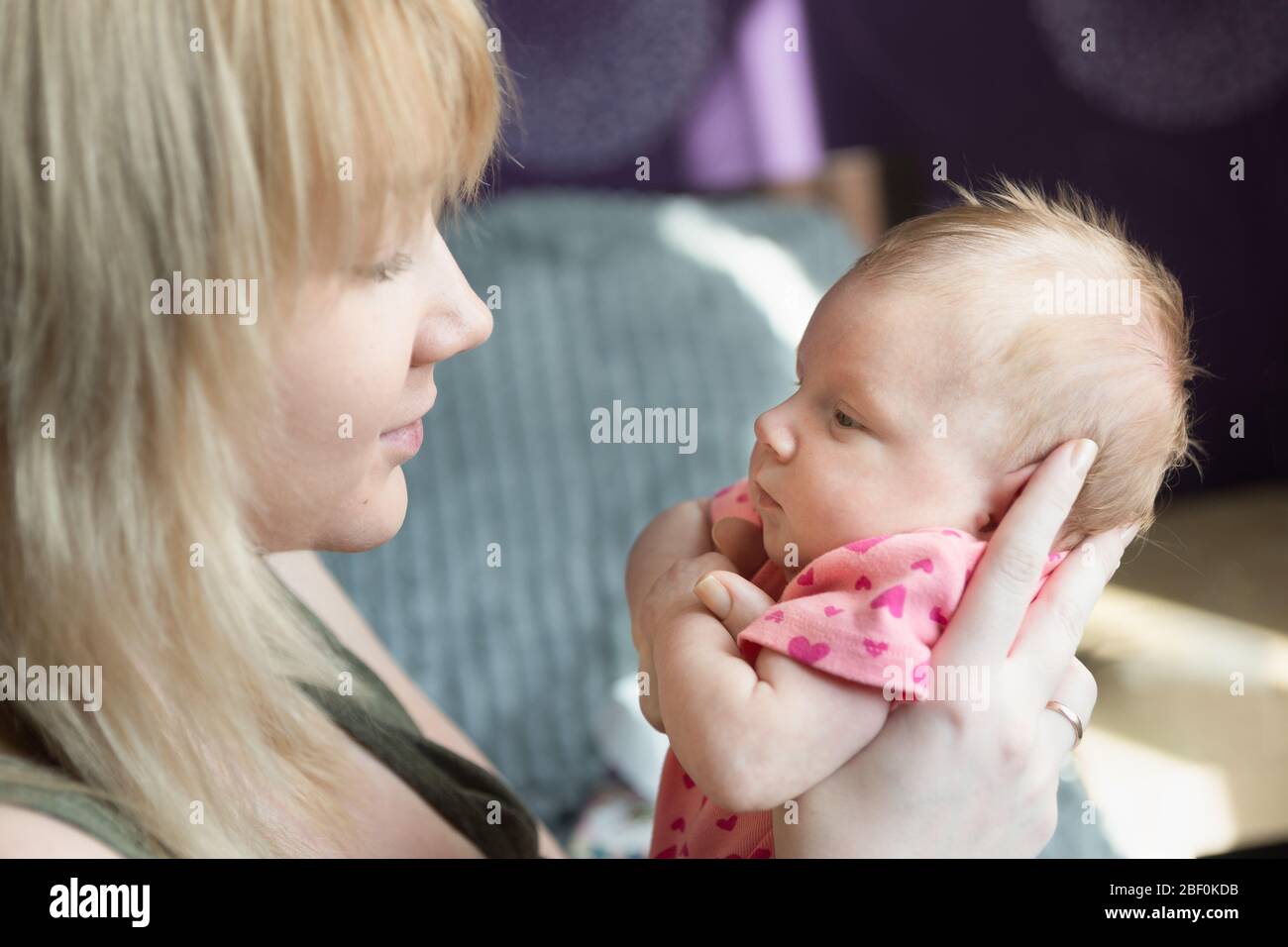 Una madre tiene una bambina neonato tra le braccia. Le madri amano e si preoccupano Foto Stock