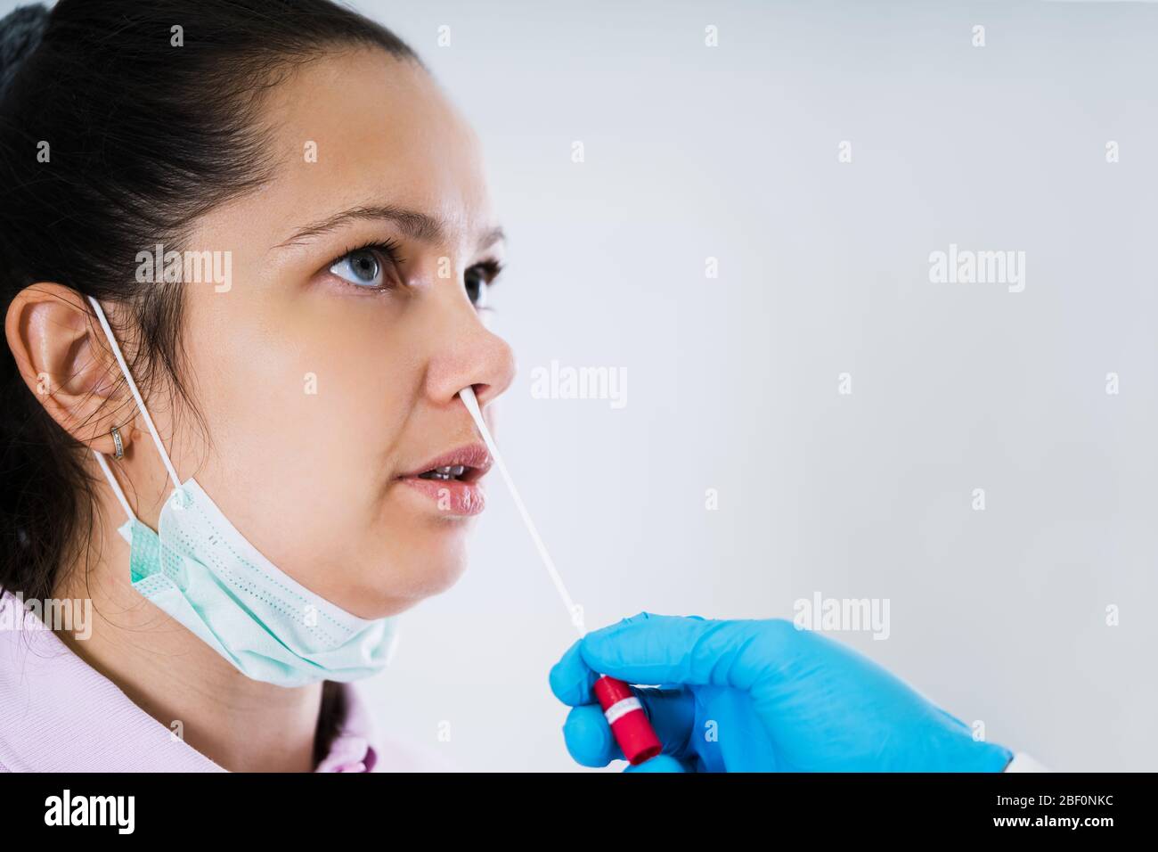 Medico che assume un campione di tampone liquido per bocca da Throat Foto Stock