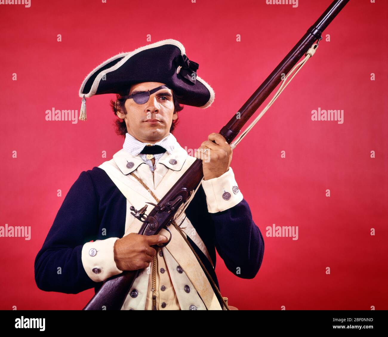 1970 UOMO CHE INDOSSA OCCHIO PATCH VESTITO COME SOLDATO CONTINENTALE RE-ENACTOR DI GUERRA RIVOLUZIONARIA AMERICANA TENENDO FLINTLOCK MUSKET - KC6808 HAR001 HARS PATCH TRICORN CONTINENTALE COME DI 1776 AUTORITÀ FLINTLOCK PATRIOT UNIFORMI GUERRA DI INDIPENDENZA FERITI CONCETTUALE RE-ENACTOR OCCHIO PATCH MUSKET RIVOLTA GUERRA RIVOLUZIONARIA AMERICANA 1770S COLONIE ARMI DA FUOCO MID-ADULTO MID-ADULTA UOMO ETNIA CAUCASICA HAR001 VECCHIO STILE Foto Stock