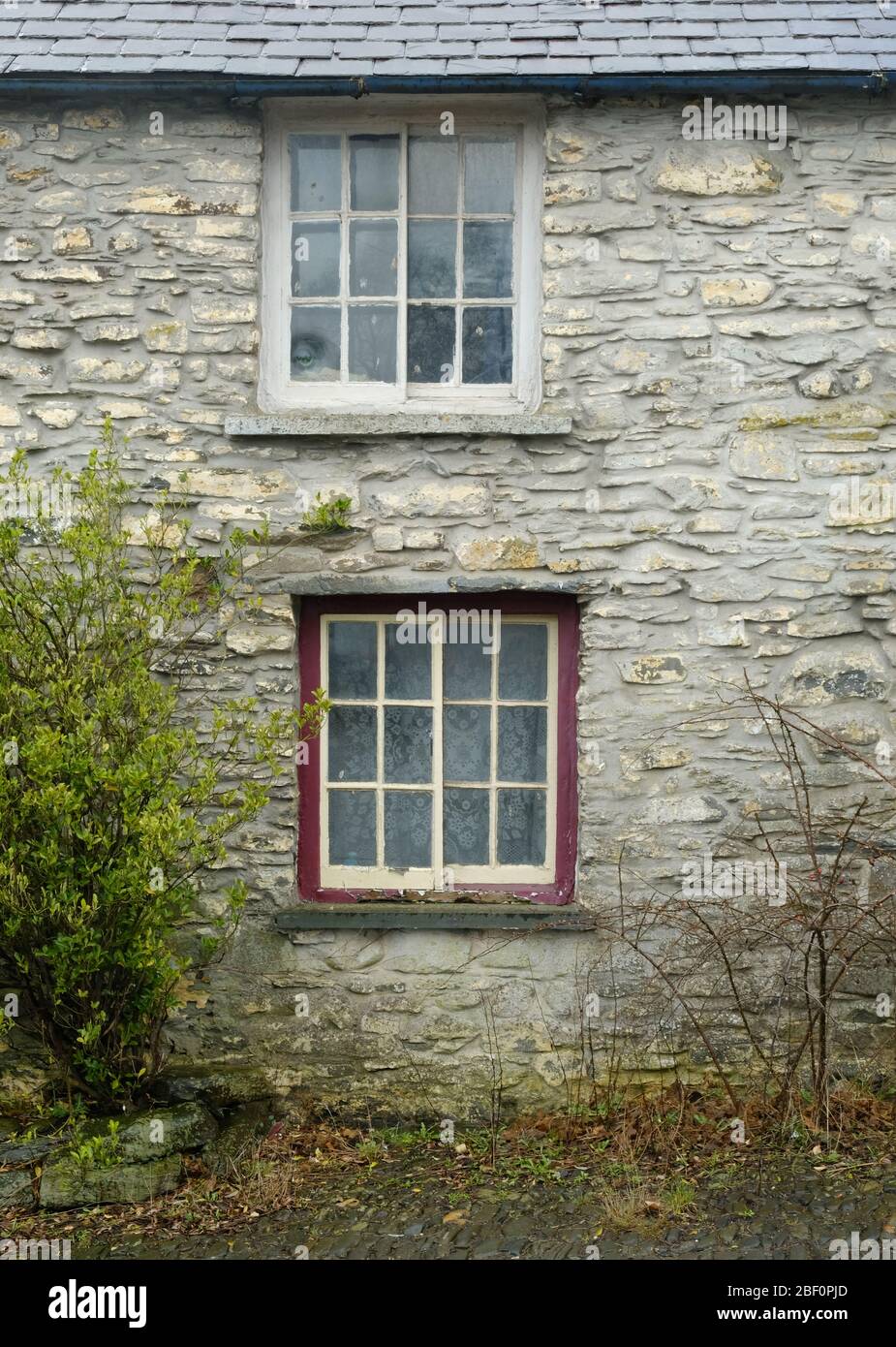 Vecchie finestre in pietra in una casa di pietra nel Galles centrale Foto Stock