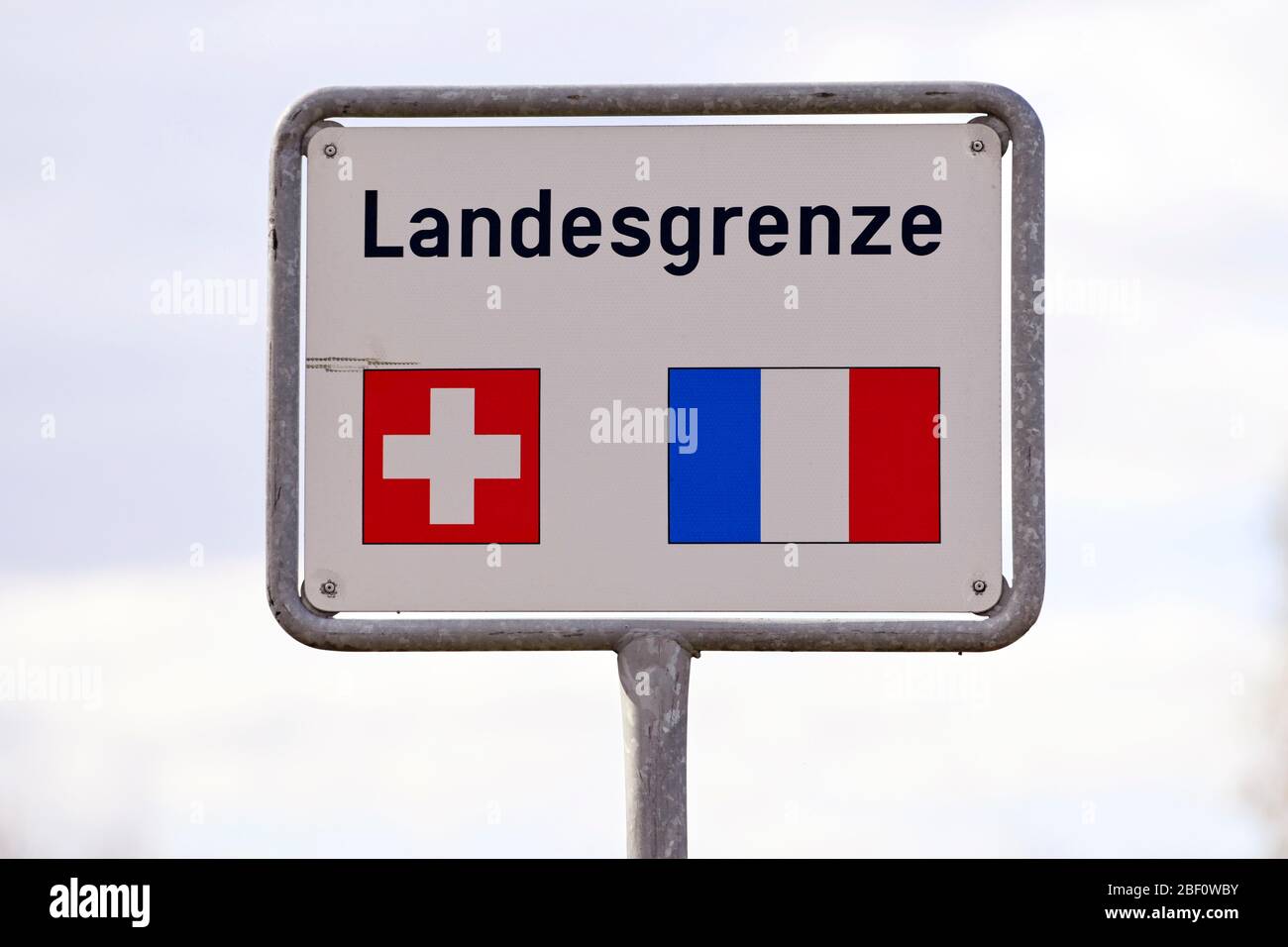 Firma confine nazionale con le bandiere Svizzera, Francia Foto Stock