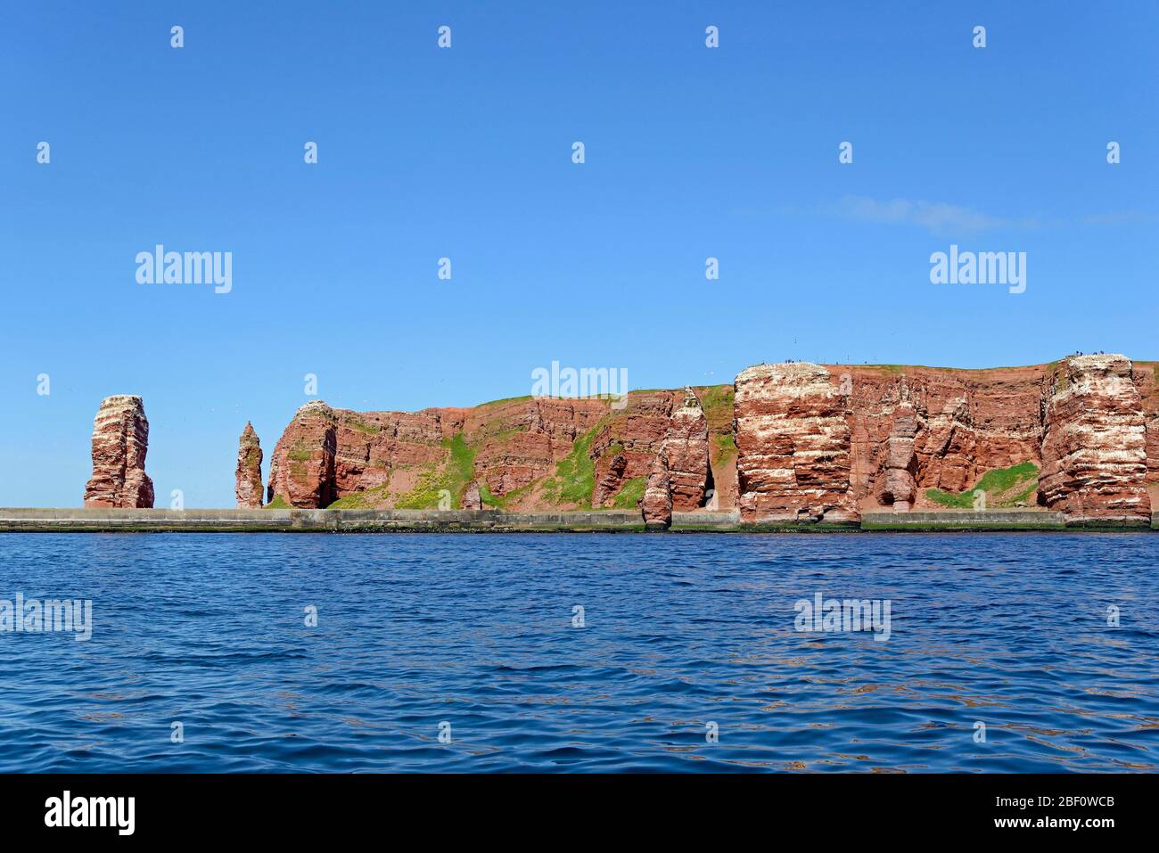 Vista dall'acqua alle rocce rosse di arenaria con Langer Anna, Helgoland, Mare del Nord, Schleswig-Holstein, Germania Foto Stock