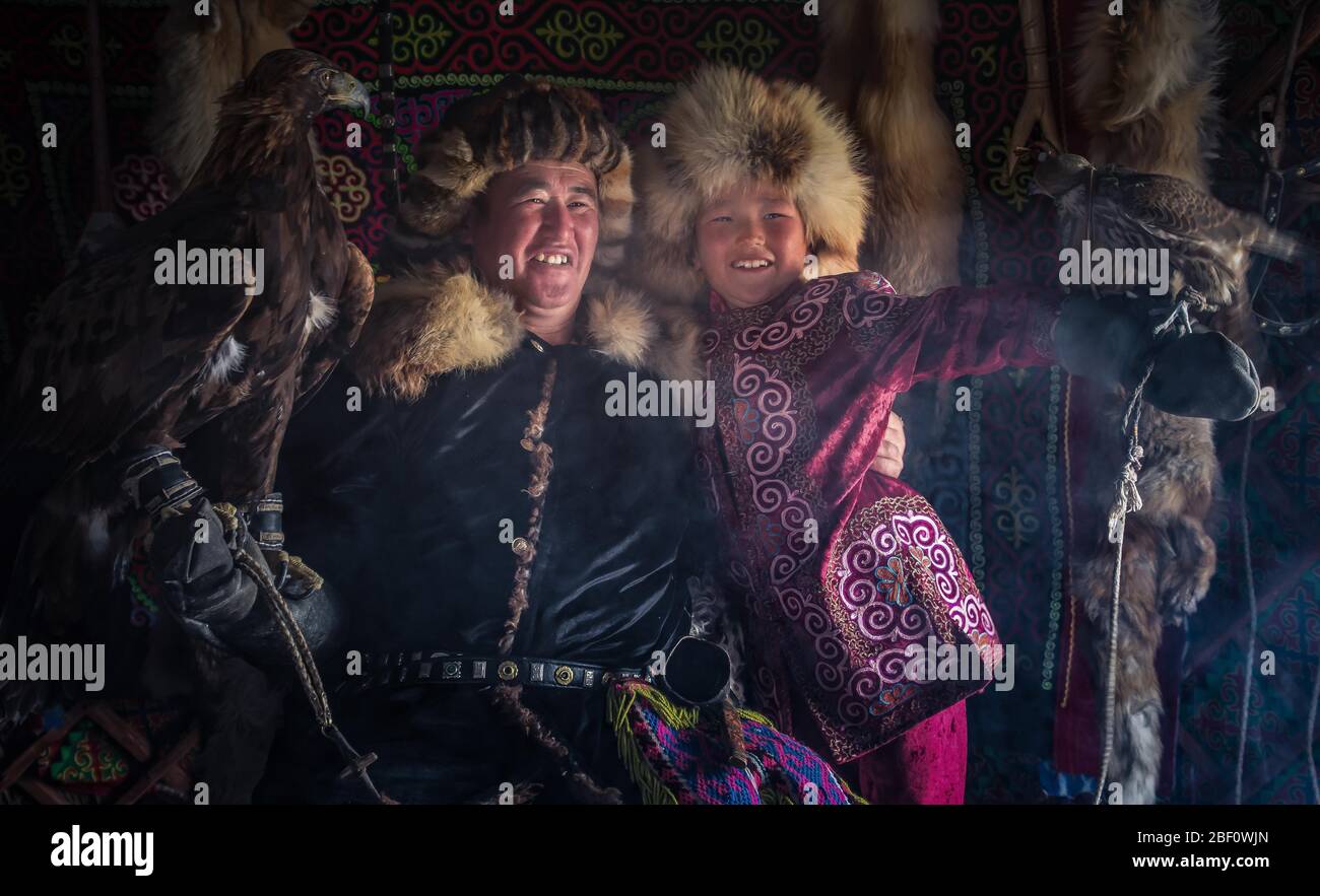 Cacciatori di aquile mongolo, padre e figlio con aquile addestrate in yurt, provincia di Bajan-Oelgii, Mongolia Foto Stock