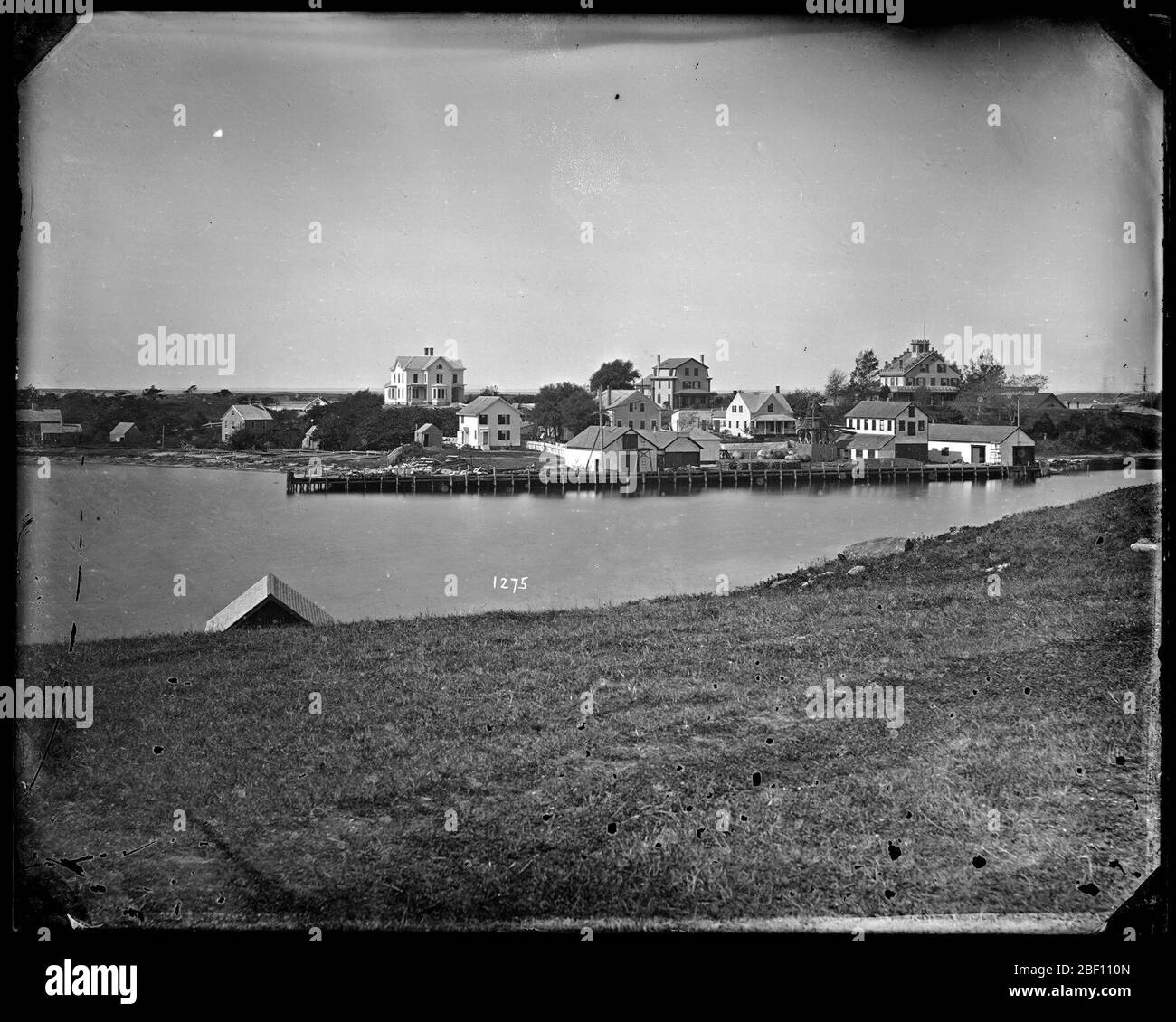 Woods Hole, Massachusetts. Litorale di corpo non identificato di acqua con le case nel background.Smithsonian Institution Archives, ACC. 11-006, Box 001, Image No. MAH-1275Smithsonian Institution Archives Capital Gallery, Suite 3000, MRC 507; 600 Maryland Avenue, SW; Washington, DC 20024-2520 Foto Stock