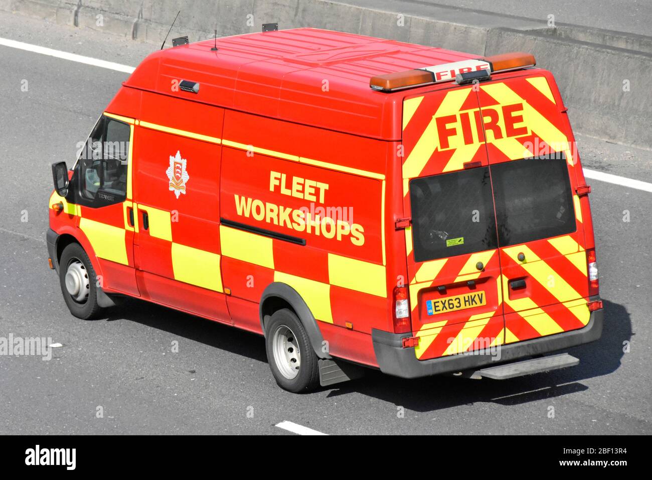 Vista dall'alto dei contrassegni di pericolo posteriori e laterali sul furgone rosso Essex County Fire Service Fleet Workshops Support guidando lungo l'autostrada Essex Inghilterra UK Foto Stock