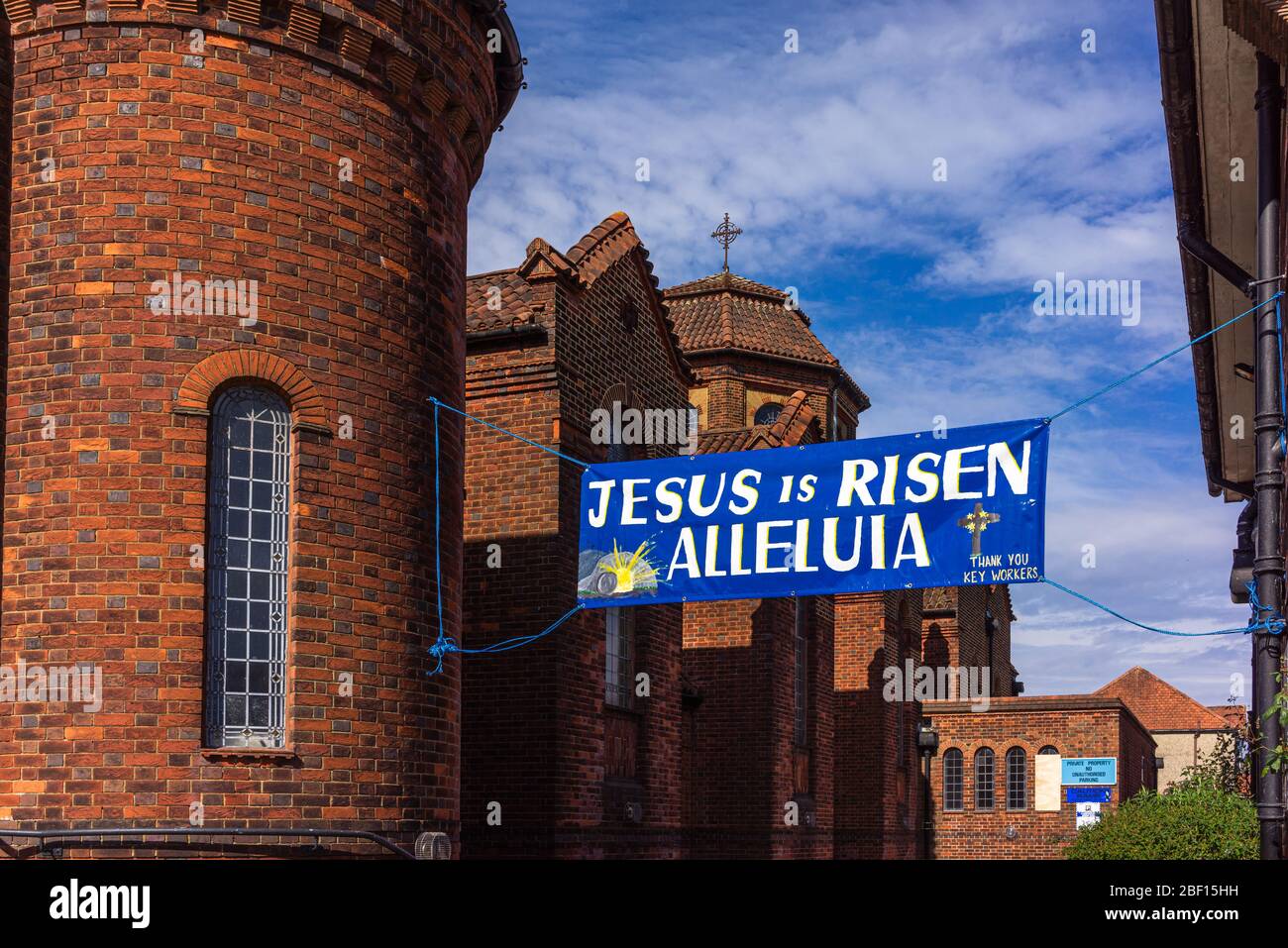 Un banner blu fuori dalla Chiesa Cattolica di San Bonifacio che legge 'Gesù è risorto Alleluia' per celebrare la Pasqua 2020, Southampton, Inghilterra, Regno Unito Foto Stock