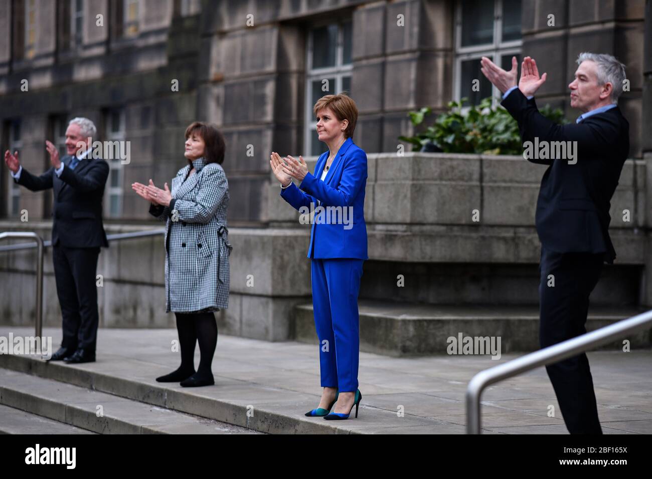 (Da sinistra a destra) Malcolm Wright Direttore Generale Direttore Generale NHS Scozia, Segretario della Sanità Jeane Freeman, primo Ministro Nicola Sturgeon e capo medico ad interim Dr Gregor Smith Scotland applaudono fuori dalla St Andrew's House, l'edificio della sede del governo scozzese a Edimburgo, Salutare gli eroi locali durante l'iniziativa Clap for Carers di Giovedi a livello nazionale per riconoscere e sostenere i lavoratori e gli accompagnatori del NHS che combattono la pandemia del coronavirus. Foto Stock