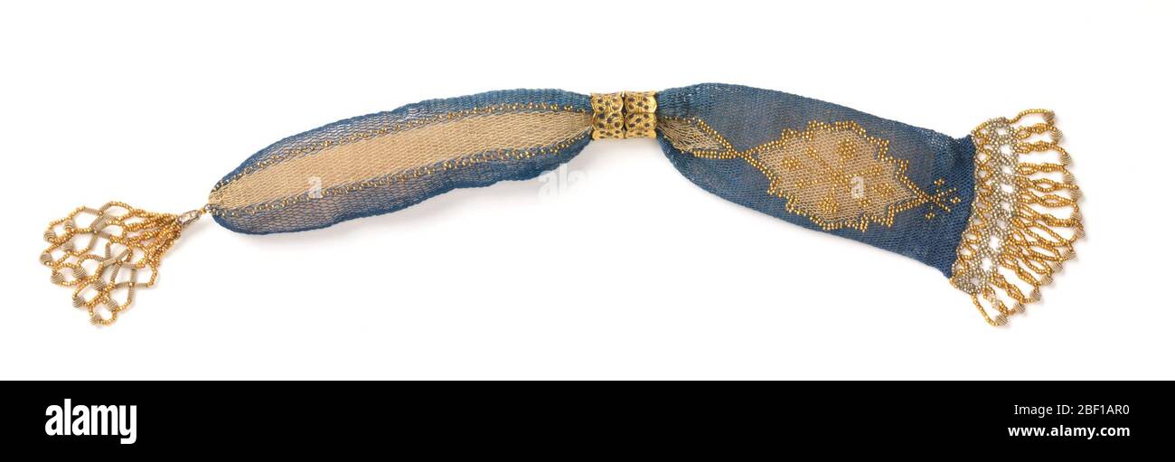 Borsa di Miss. Rete di seta blu con area asimmetrica di seta bianca che forma una barra e motivo a diamante dentellato. Aree bianche delineate con perle d'oro; stella a otto punte con perle d'oro all'interno di un'area bianca a forma di diamante. Due anelli d'oro con aree floreali blu all'apertura. Foto Stock