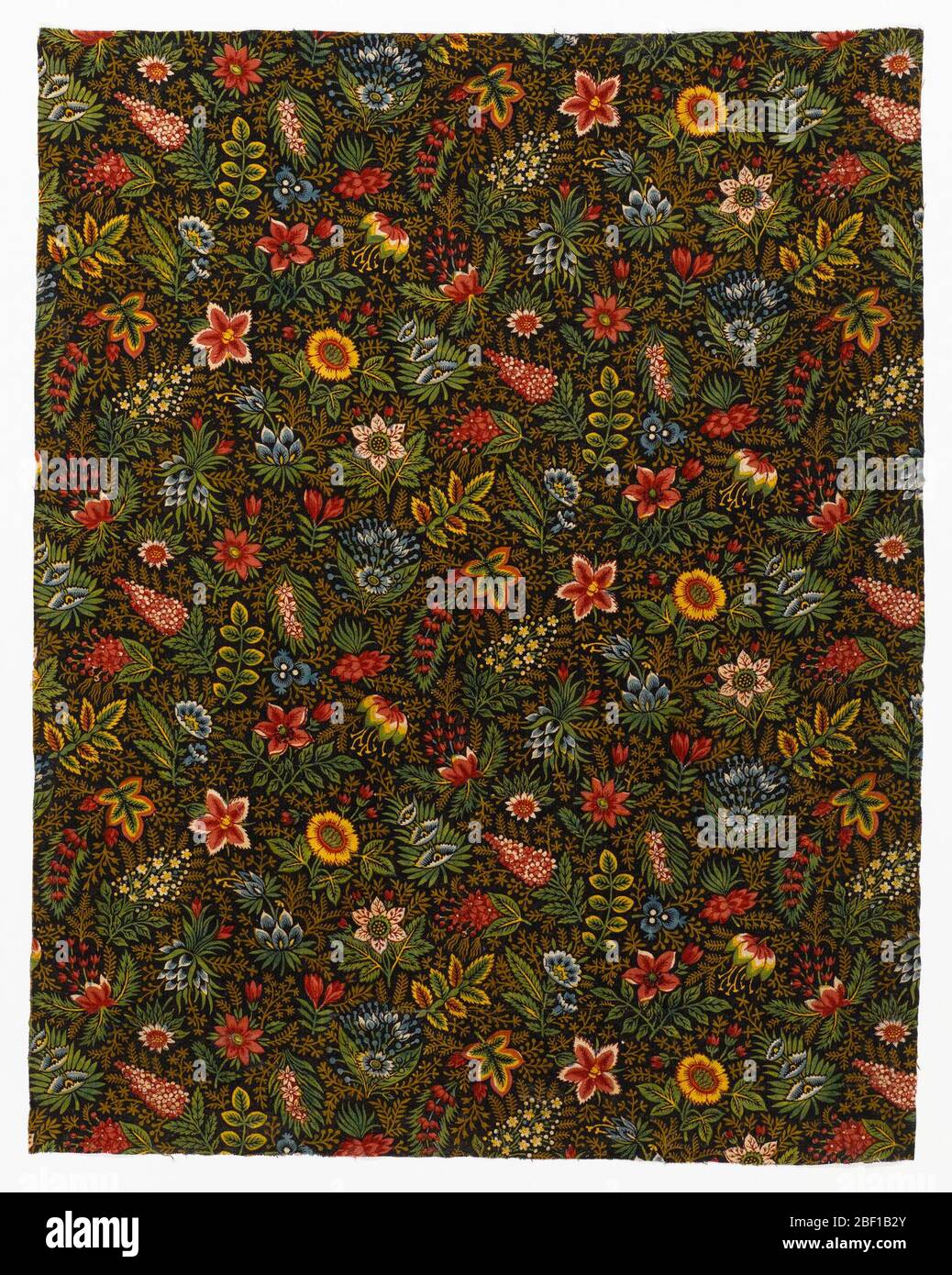 Tessile. Frammento di cotone stampato con un disegno su piccola scala di fiori dai colori vivaci e sottili rametti di foglie su sfondo marrone scuro. Stampato in diverse sfumature di verde, blu, rosso e giallo, con riservato bianco. Foto Stock