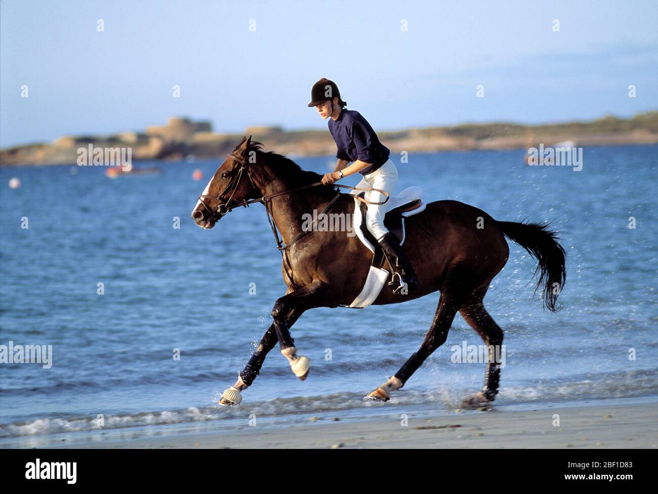 Guernsey. Giovane donna a cavallo sulla spiaggia. Foto Stock