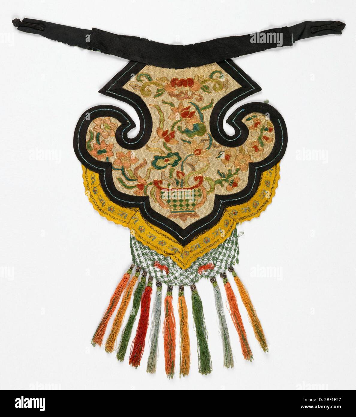 Collare. Tessuto nero fissato a grande tessuto simmetrico con bordo nero che circonda tessuto naturale colorato con vaso e ricamo floreale. Foto Stock