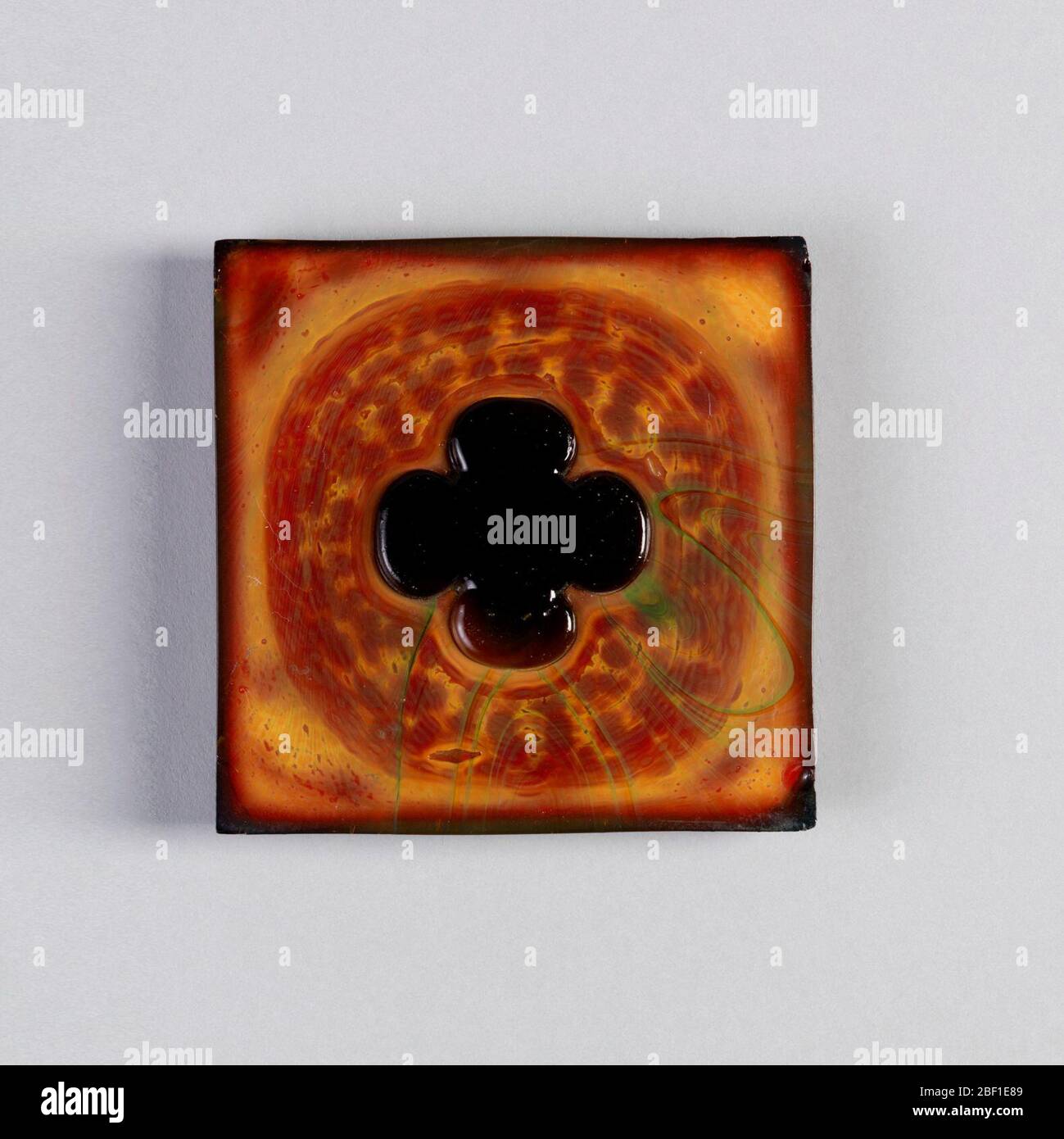 Affiancamento. Fondo rosso e giallo senape con trifoglio centrale scuro a quattro foglie. Foto Stock