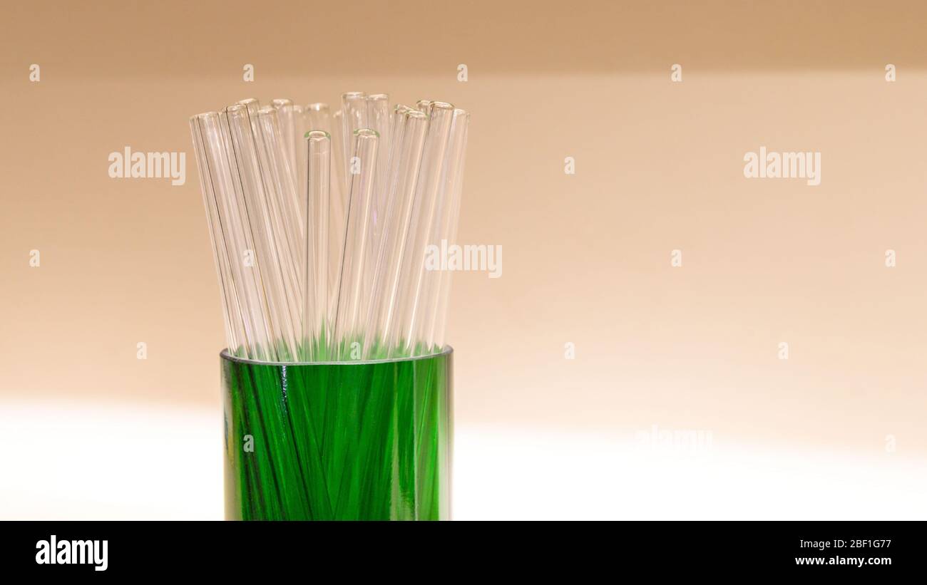 Sostituzione delle cannucce in plastica. Cannucce riutilizzabili in vetro trasparente eco-compatibili, con messa a fuoco selettiva. Zero sprechi, nessun concetto di plastica. Foto Stock