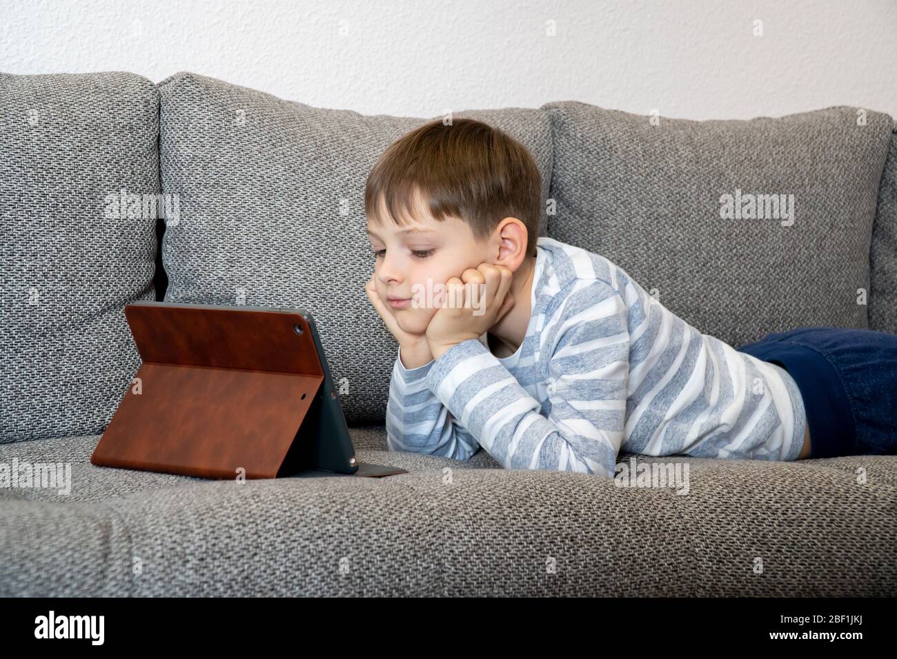 Formazione online a distanza. Un ragazzo studia a casa e fa i compiti scolastici. Un apprendimento a distanza a casa. Foto Stock