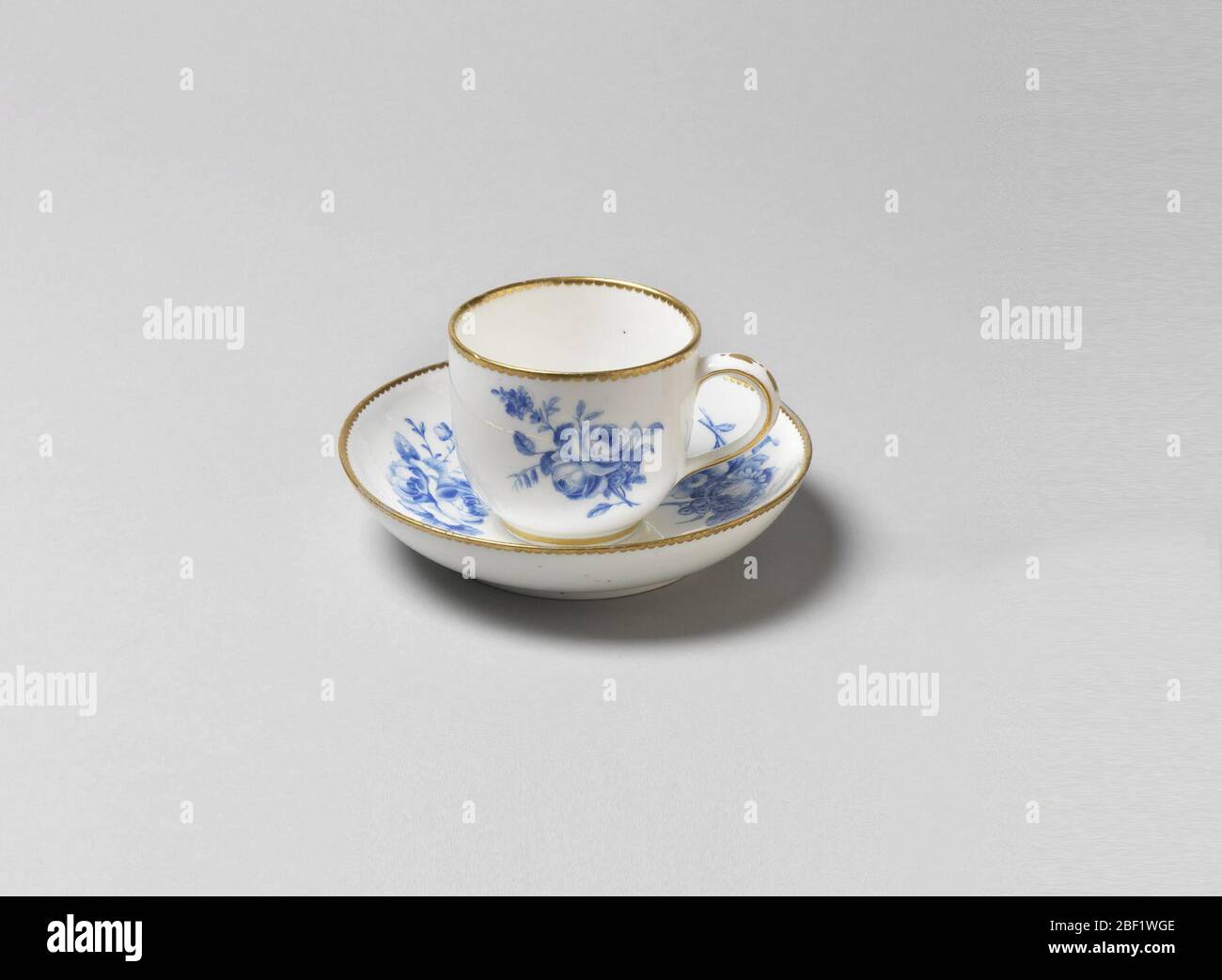 Tazza e piattino. Tazza e piattino con decorazione floreale blu. Doratura sui cerchi. Foto Stock