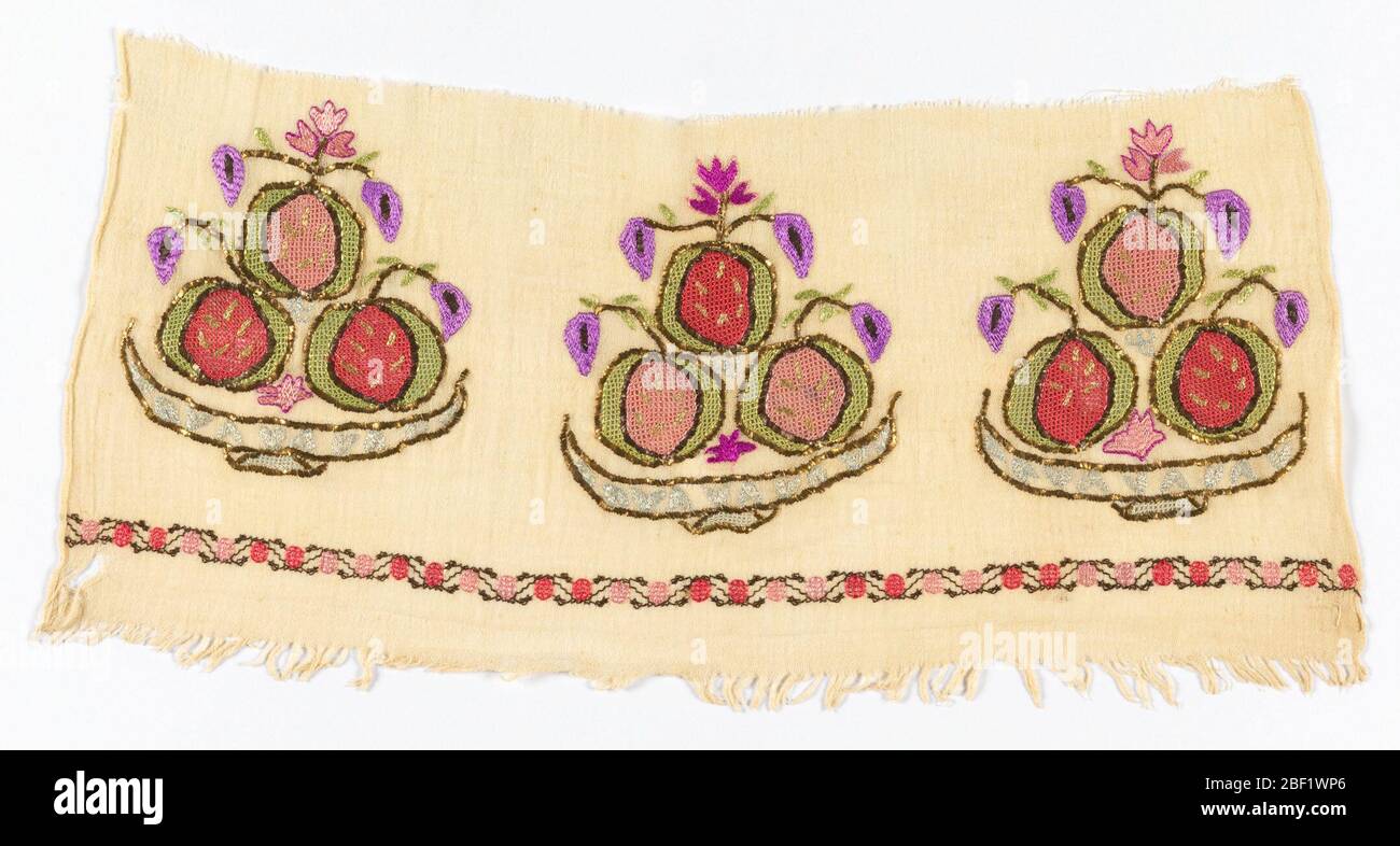 Frammento di bordo. Frammento di bordo ricamato in un disegno multicolore di fiori e frutta stilizzata in una ciotola poco profonda. Bordo a zigzag con punti rosa scuro e chiaro. Foto Stock
