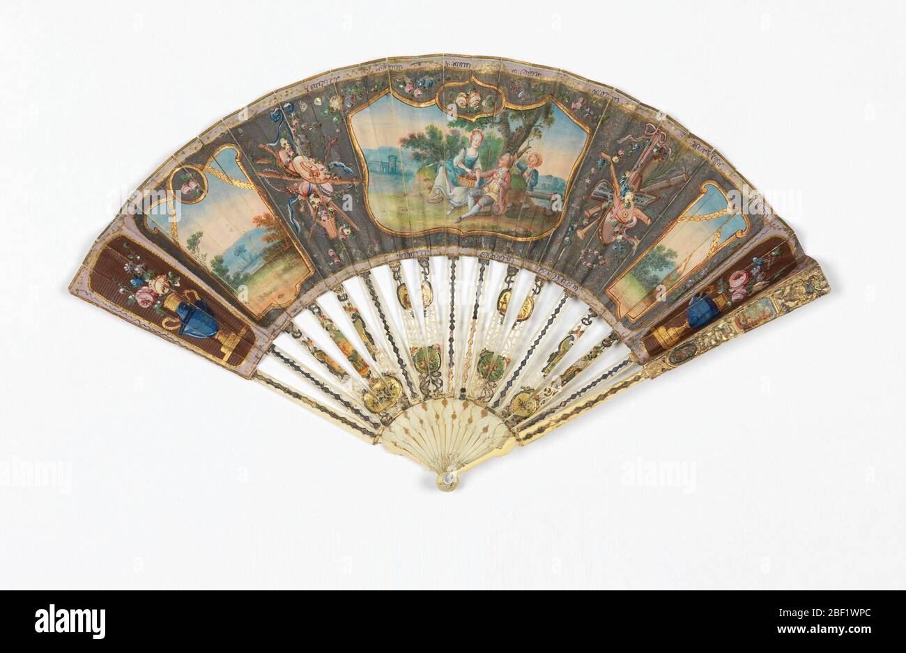 Ventola e custodia pieghettate. Grande cartouche centrale con paniere di ciliegie e due giovani in stile Boucher. Due piccoli tocchi laterali con paesaggi eroici. Spazi tra riempiti di ornamenti di vita ferma di stile Luigi XVI. Foto Stock
