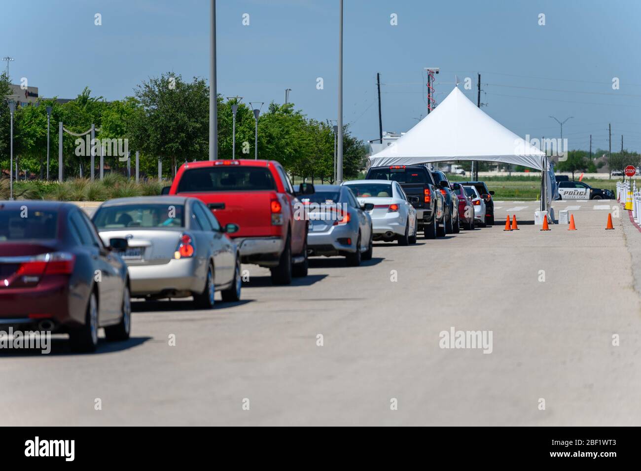 Sugar Land, Texas - 16 aprile 2020: Le auto si allineano al centro di test drive-through della città COVID-19 Foto Stock