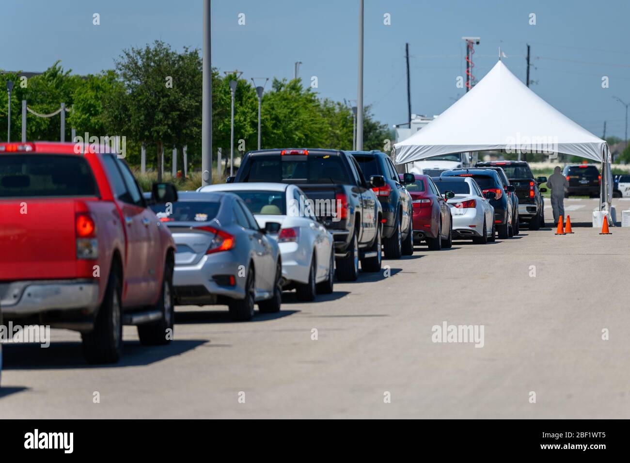 Sugar Land, Texas - 16 aprile 2020: Le auto si allineano al centro di test drive-through della città COVID-19 Foto Stock