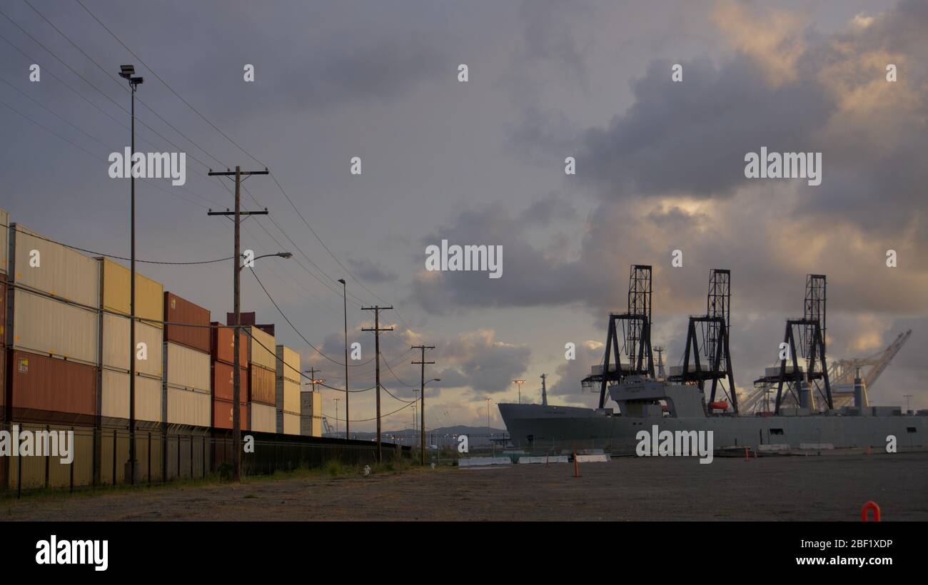 Nave da guerra portavalori SS Cape Mohican SEABEE presso terminal container per spedizioni internazionali con gru di spedizione. Outer Harbour, Porto di Oakland, Stati Uniti. Foto Stock