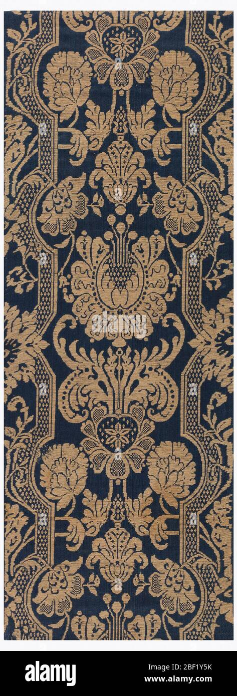Tessile. Il motivo è bianco su uno sfondo blu e ha un disegno simmetrico di fiori tra le fasce reticolari su entrambi i lati. Foto Stock